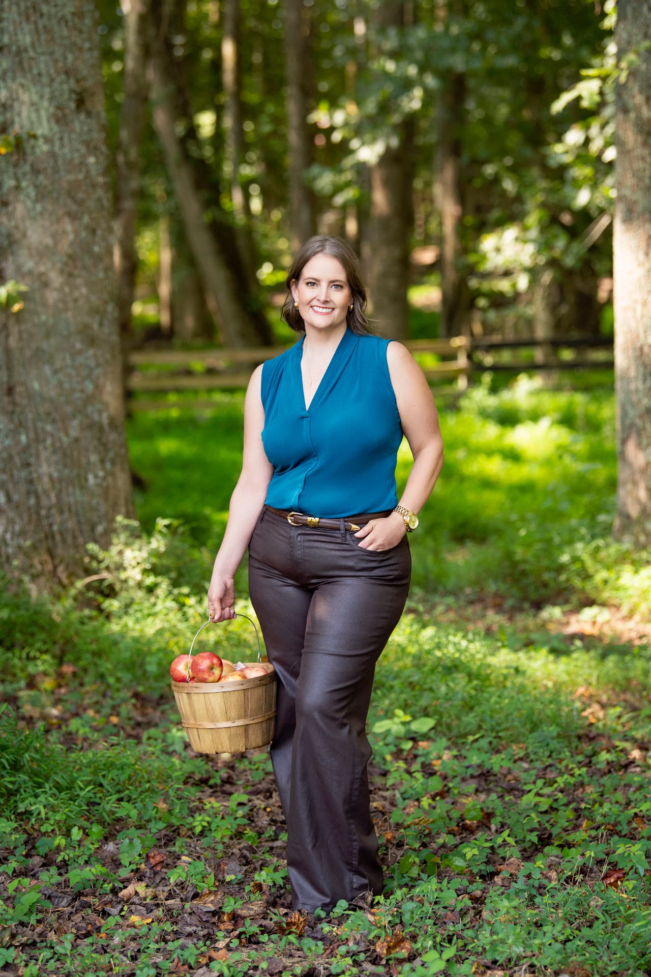 Melissa Moss, CERTIFIED FINANCIAL PLANNER® professional, outdoors carrying a basket of apples